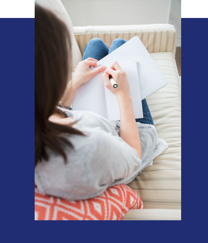 Women sitting in white sofa writing down in paper