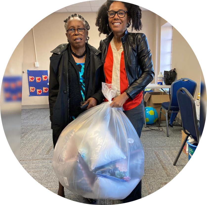 A photo of Jamilah and a lady donating a bag of pillows to Missing Pieces Support Group